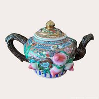 Angled view showing front peach appliqué, branch handles and painted decoration