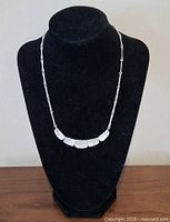 Full view of necklace on display stand showing overall design and length