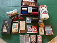 Overall view of poker chip case, playing cards, dominoes, dice and table cover