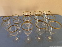 Fourteen Lenox stemware pieces arranged on table showing gold rims