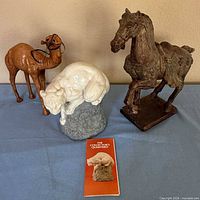 Three animal sculptures and booklet grouped