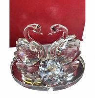 Front view of crystal swan figurine on mirrored base showing details and accent stone