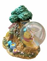 Front view of snow globe showing Pooh and Piglet inside globe, tree base, honey pots.