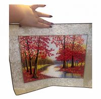 Full view of embroidered landscape panel showing scene, borders and hand for scale