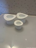 Three milk glass pieces grouped to show size difference and pattern