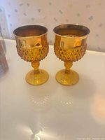 Front view of both amber hobnail goblets