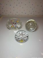 All three paperweights displayed: snowflake, bubble sphere, faceted fish scene