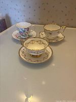 Front view of three teacup and saucer sets