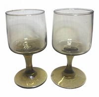 Front view of two olive green smoked glass goblets