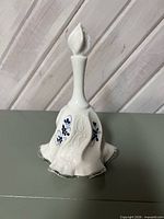 Full view of bell showing silver crest edge and hand-painted blue flowers