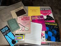 Top-down view of all ten music books, blank sheets and cloth folio on countertop