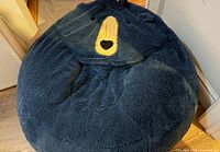 Top view of dark blue bear-shaped bean bag showing overall shape, face detailing and material texture