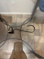 Overall view of metal candle snuffer on glass table