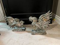 Both cast iron rooster bookends on carpet