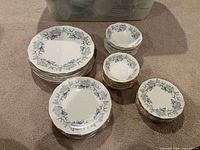 Four stacks of Royal Albert Silver Maple plates and bowls displayed on carpet