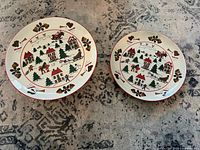 Front view of both matching Christmas pattern plates, showing size difference and design.