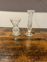 Two clear cut crystal vases, squat pedestal vase left, slender bud vase right