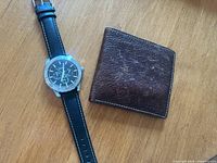 Front view of watch and wallet side by side