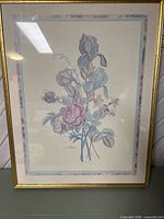 Front view of framed floral print with gold frame and double mat