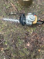 Full view of hedge trimmer lying on ground