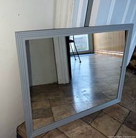 Front view of rectangular mirror showing grey frame and reflective glass