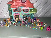 Front view of playhouse with animal figures and accessories arranged