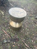 Bronze-tone hourglass metal outdoor side table on ground