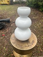 Full view of white three-tier outdoor vase on stand