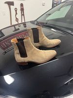 Side view of both boots on car hood showing suede uppers and elastic panels