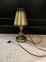 Side view of brass table lamp with metal shade and power cord