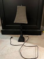 Full view of lamp showing base, column, plaid shade, and power cord