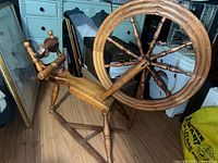 Overall view of wooden spinning wheel showing wheel, flyer, treadle and frame