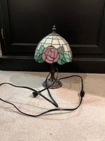 Front view showing full lamp, stained glass shade, metal base, attached power cord