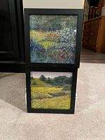Two framed square nature photographs stacked vertically, showing meadow and field scenes