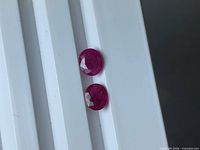 Two faceted oval rubies on white background