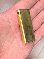 Front view of slim gold-tone ribbed lighter