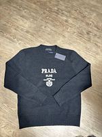 Front view of sweater showing Prada Milano logo and tag