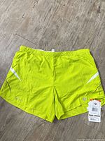 Front view of neon yellow Pearl Izumi running shorts with tags attached