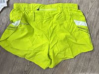 Back view of lime Pearl Izumi shorts showing zipper pocket and reflective accents