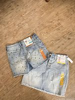 Front of both denim pieces displaying tags, star print shorts, distressed skirt