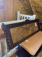 Full view of oak framed mirror showing size and loft storage context