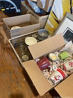Wire basket with Mason jars, boxes containing dishes and mugs