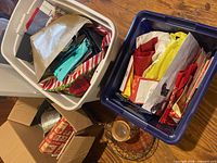 Two totes filled with gift bags, tissue, cards, wire basket and jar, partial view of cookbooks