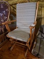 Front view of St. Yves wood glider rocking chair showing cushions and base