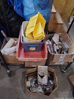 Assortment of boxes with paint tray, tote, saw guides, caulk, sandpaper, plumbing and electrical items