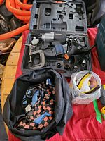 Impact wrench set in open case with sockets, C-clamp, straps bag, hardware jar visible