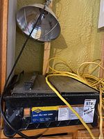 QEP 500 wet tile saw with yellow cord and clamp lamp positioned above