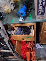 Overview showing reciprocating saw, hammer, chain, extension cord, boat kit in cabinet