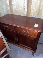 Front view of wood buffet showing top surface, drawer, doors