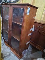 Front view of wood hutch with glass doors and ornate pulls